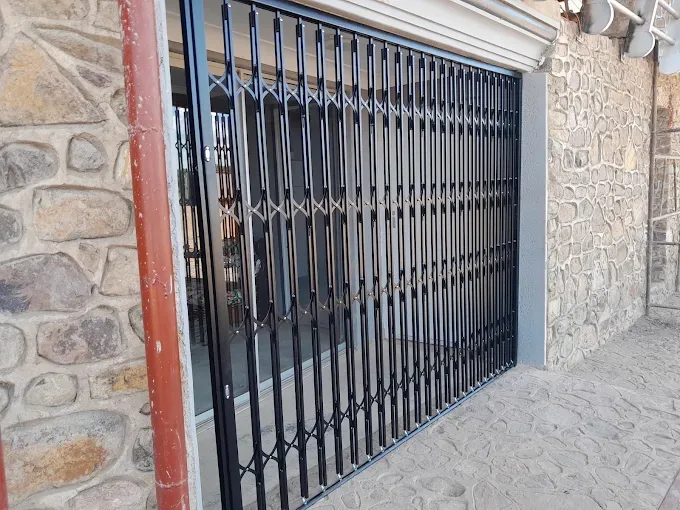 Full-width expanding security gate on a stone facade